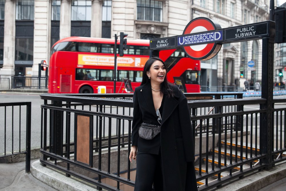 une femme devant une station de métro à Londres