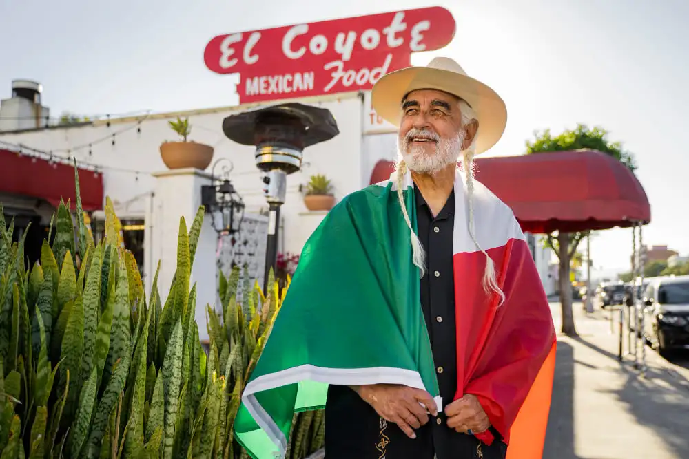 Un touriste avec le drapeau mexicain devant un restaurant local