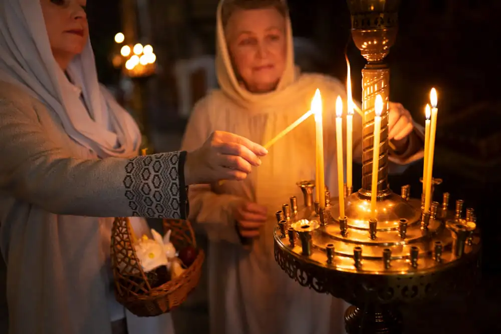 Femmes allumant des bougies lors d'une cérémonie orthodoxe à Horile, Ukraine