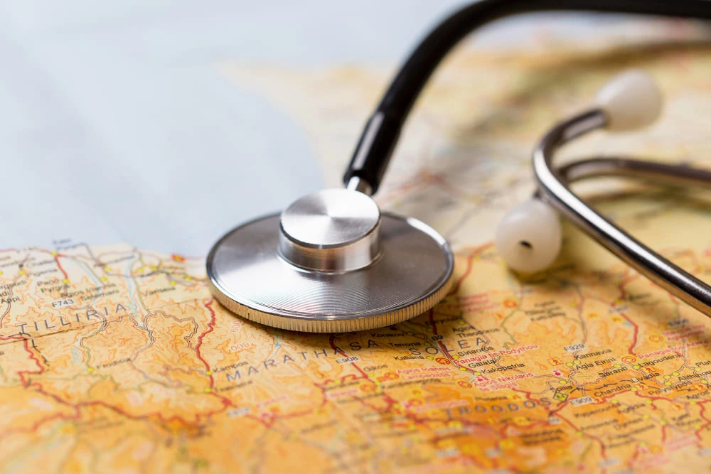 Stéthoscope posé sur une carte du monde illustrant l’assurance santé internationale pour expatriés