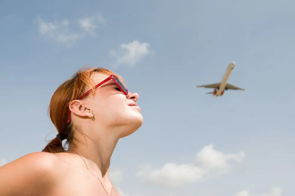 Une femme prend des vitamine avec le soleil avant de prendre l'avion